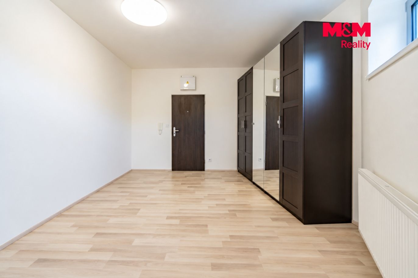 Minimalistická předsíň s tmavými skříněmi.png