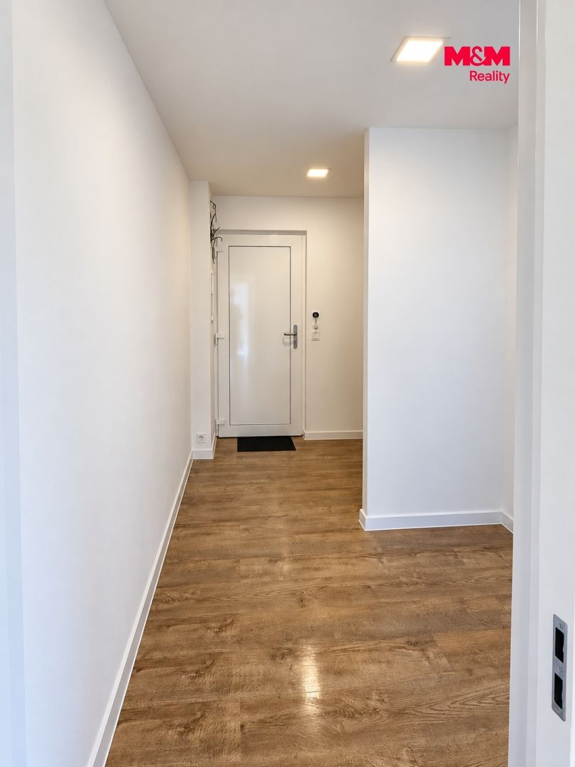 Světlá bílá chodba s dřevěnou podlahou.png