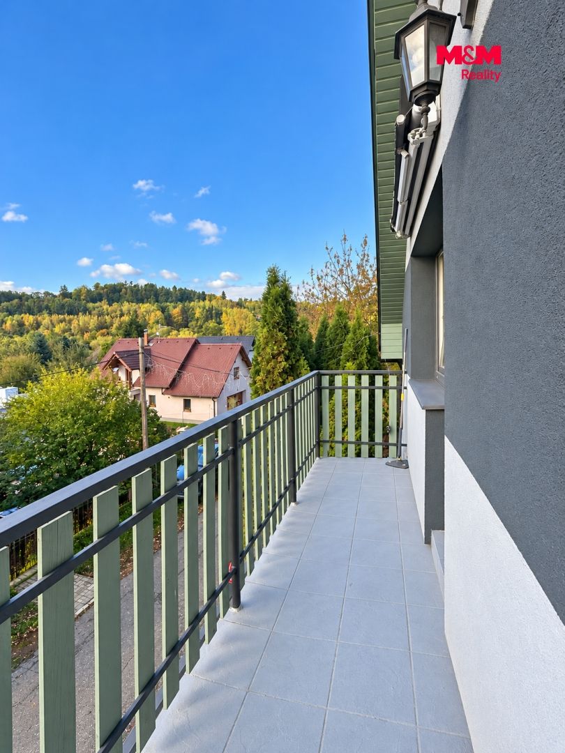 Prosvětlený balkon s výhledem na město.png